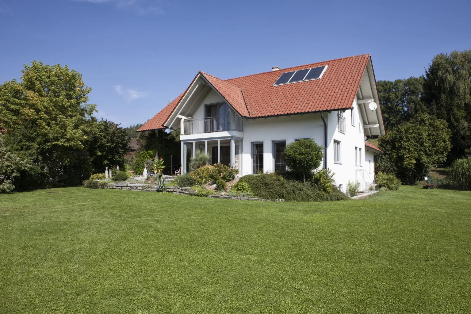 Einfamilienhaus mit Vorgarten als Symbol für Wohneigentum und das Medianvermögen Deutschlands