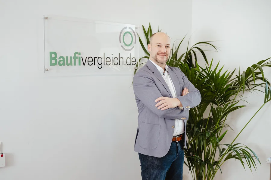 Salomon Davin, Gesch&auml;ftsf&uuml;hrer von Baufivergleich in Kassel, im B&uuml;ro vor der Baufivergleich-Wand