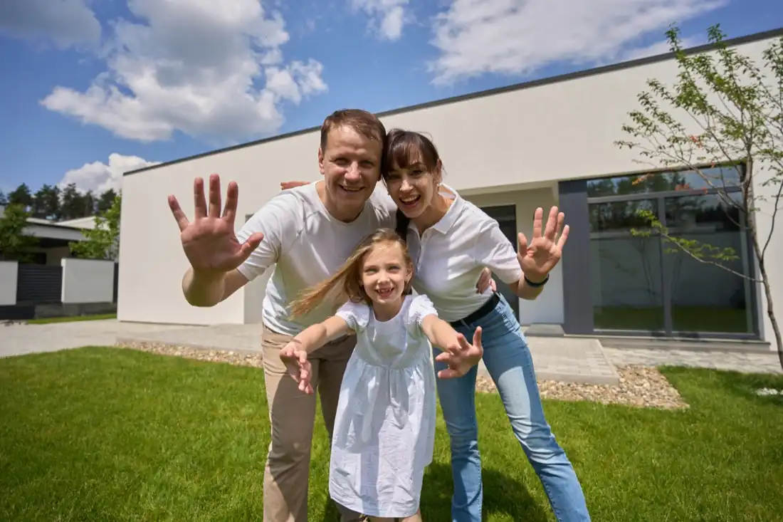 Familie vor ihrem Haus nach der vorzeitigen Ablösung des Darlehens